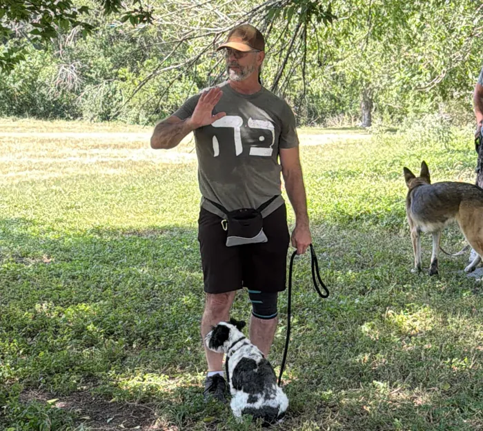 Rusty Nokes working a dog on leash in the field